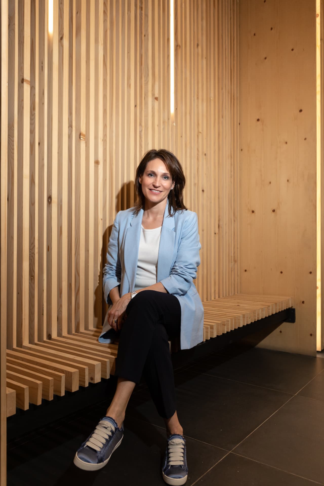 Elena Galante sentada ante un panel de madera